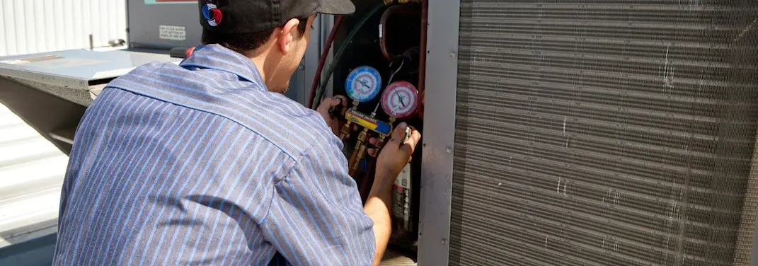 HVAC technician servicing a condenser unit in Antioch